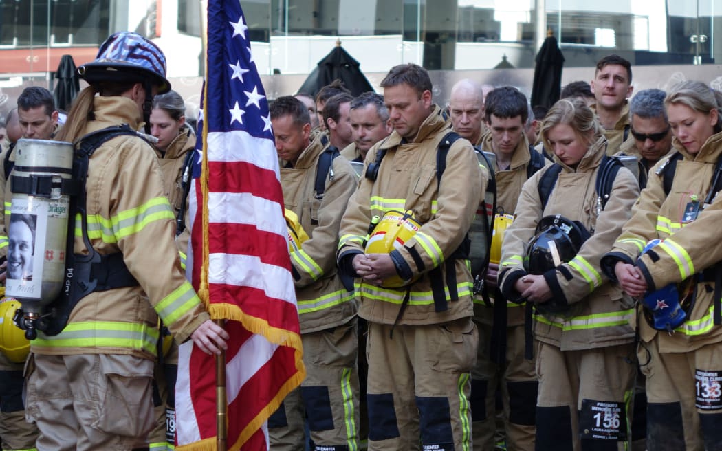 Firefighters bow their heads ahead of beginning the climb up Auckland's Sky Tower in honour of those who lost their lives in New York on 11 September 2001.