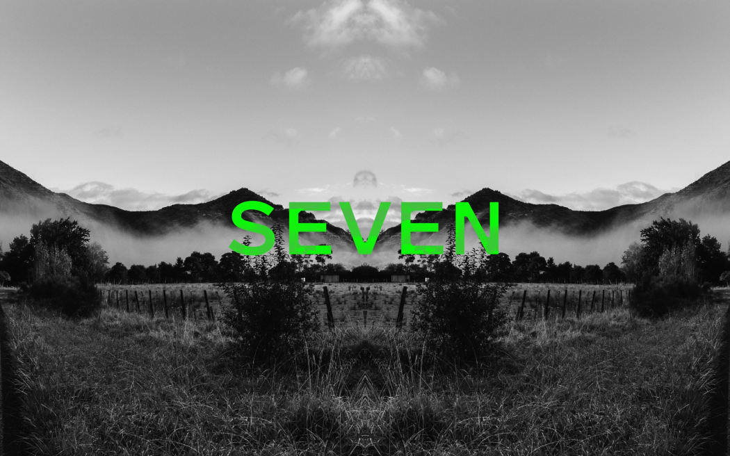 Podcast episode image for the 'Mr Lyttle Meets Mr Big' podcast. A moody black and white photograph of a misty field with hills in the background is mirrored vertically creating a Rorschach like effect with the episode number 'SEVEN' overlaid in vibrant green.