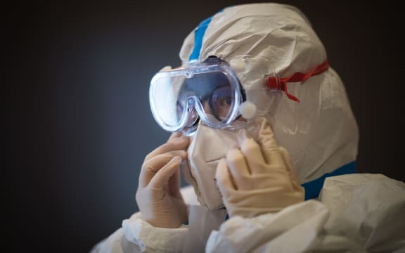 A member of the medical team of the Second Military Medical University puts on protective clothing at Hankou Hospital in Wuhan on 27 January, 2020.
