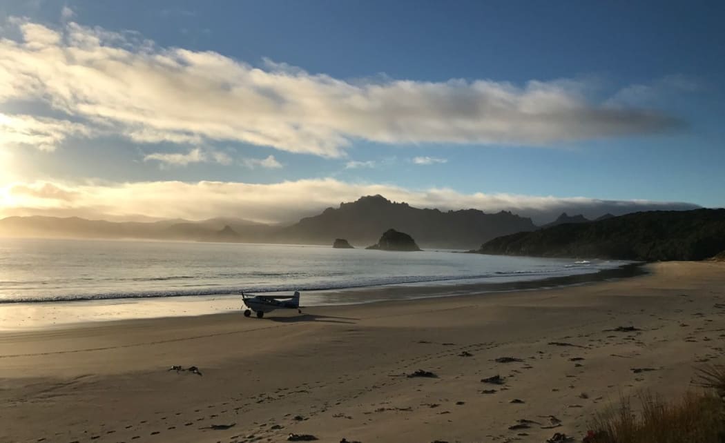 JEM the Cessna has been ferrying passengers and equipment to and from Whenua Hou / Codfish Island for 26 years. Stewart Island's Ruggedy Range is in the background.