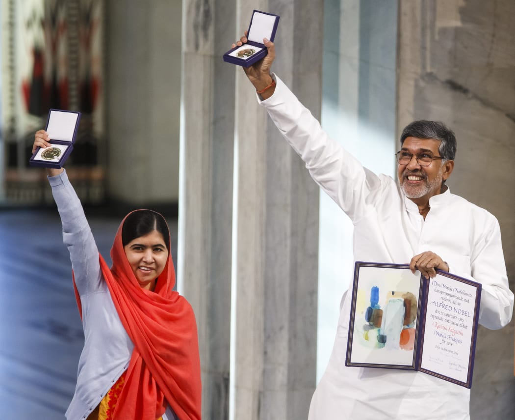 Malala Yousafzai (left) and Kailash Satyarthi display the Nobel Prize medals and diplomas during the awards ceremony.