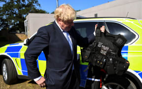 Conservative MP and leadership contender Boris Johnson holds a bulletproof vest during his visit to the Thames Valley Police Training Centre.