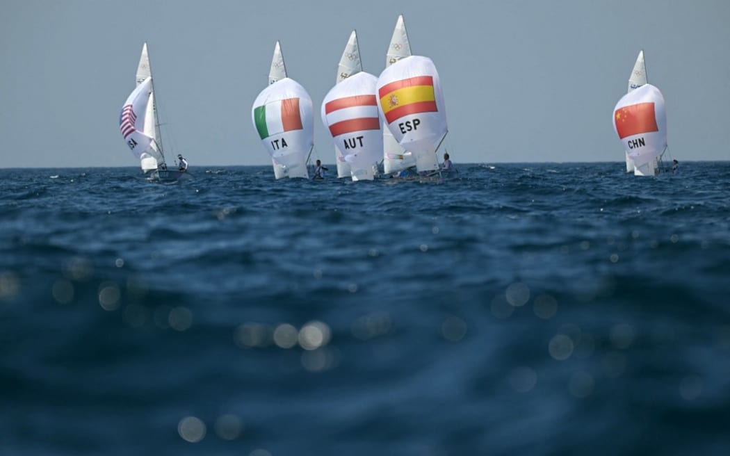 Italy's duo Elena Berta and Bruno Festo, Austria's duo Lara Vadlau and Lukas Maehr ans Spain's duo Jordi Xammar Hernandez and Nora Cabot Brugman compete in race 5 of the mixed 470 double-handed dinghy event during the Paris 2024 Olympic Games sailing competition at the Roucas-Blanc Marina in Marseille on August 4, 2024. (Photo by NICOLAS TUCAT / AFP)