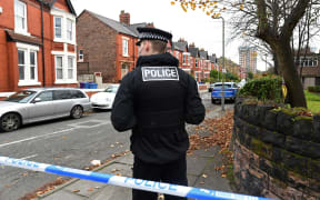 A police officer works inside a cordoned-off area on Rutland Avenue, the place where police have confirmed the passenger of the taxi that later exploded outside the Women's Hospital in Liverpool was picked up, on 15 November 2021.