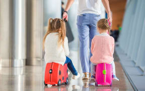 Children at airport with suitcases
