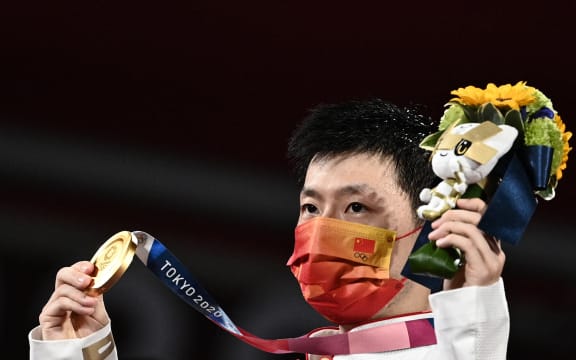 Gold medallist China's Ma Long poses with his medal during the men's singles table tennis medal ceremony at the Tokyo Metropolitan Gymnasium during the Tokyo 2020 Olympic Games in Tokyo on July 30, 2021.