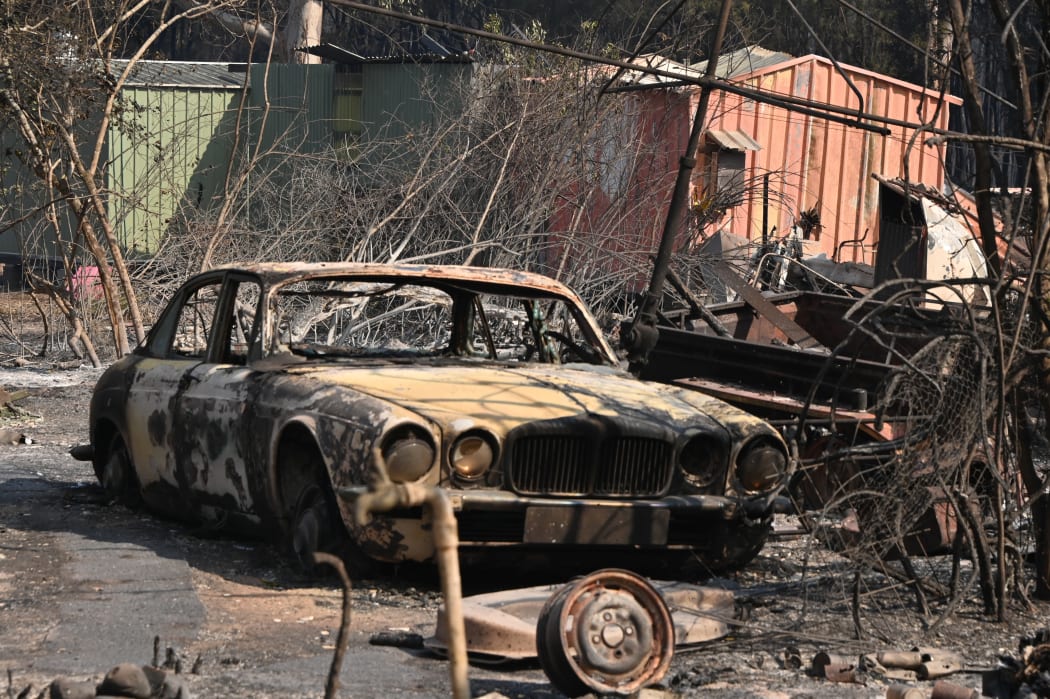 A burned car at a property destroyed by fire at Old Bar, 350km north of Sydney on Sunday.