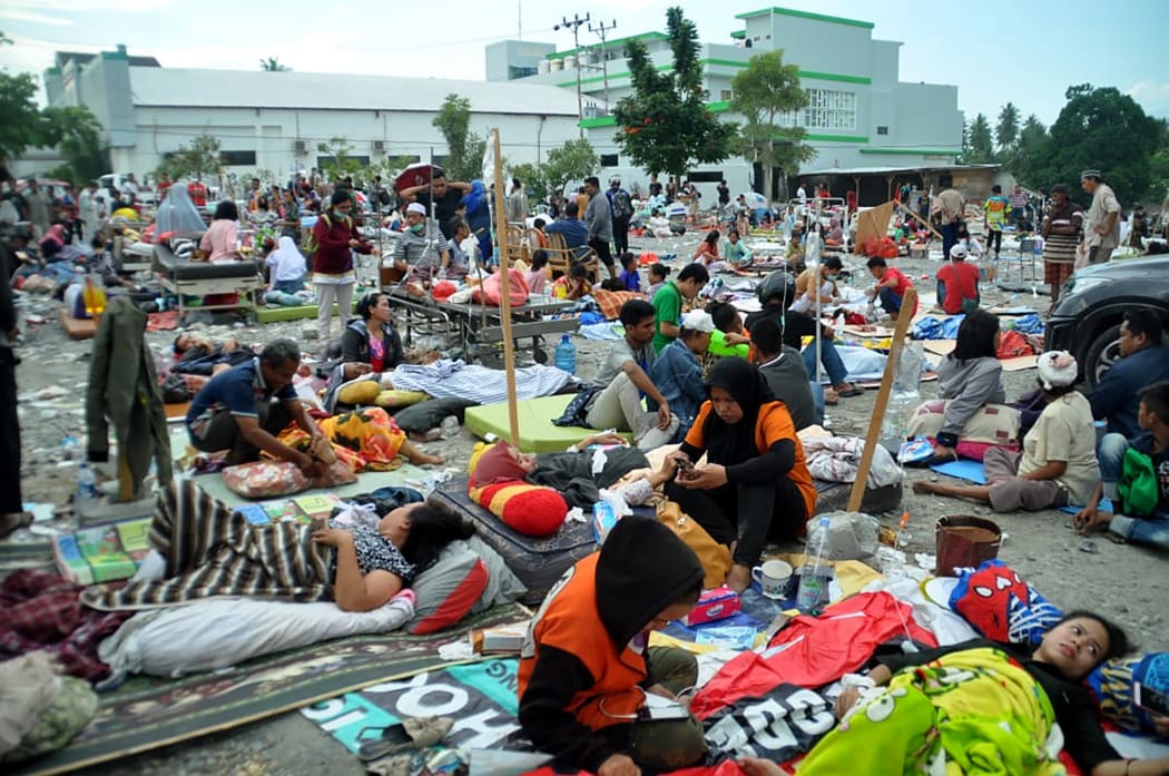 Medical team members help patients outside a hospital after an earthquake and a tsunami hit Palu, on Sulawesi island.