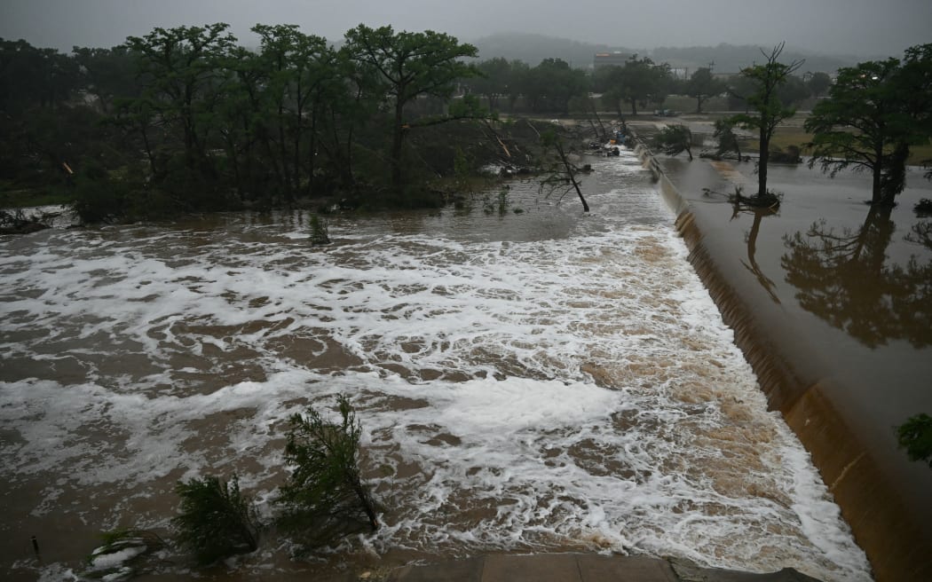 A photo shows flooding caused by a flash flood at the Guadalupe River in Kerrville, Texas, on July 5, 2025. Rescuers were desperately searching for at least 20 girls missing from a riverside summer camp, officials said on July 5, after torrential rains caused a "catastrophic" flash flood that killed at least 24 people as it swept through south-central Texas. (Photo by RONALDO SCHEMIDT / AFP)