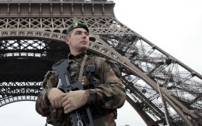 A French soldier in front of the Eiffel Tower as Paris is placed under the highest alert status.