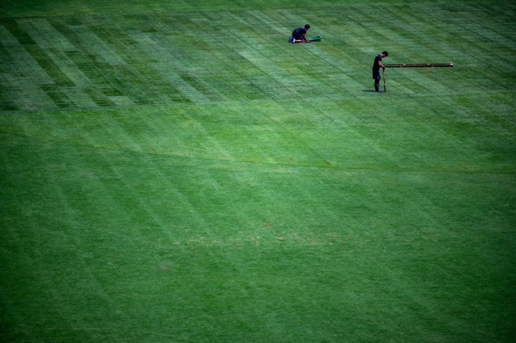 Staff members work on the pitch at the Olympic Stadium in Tokyo, the morning after the closing ceremony for the 2020 Tokyo Olympic Games.