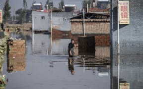 A man makes his way along a flooded area after heavy rainfall in Jiexiu in the city of Jinzhong in China's northern Shanxi province on 11 October 2021.