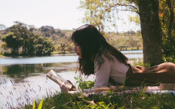 Stock image of woman reading outdoors