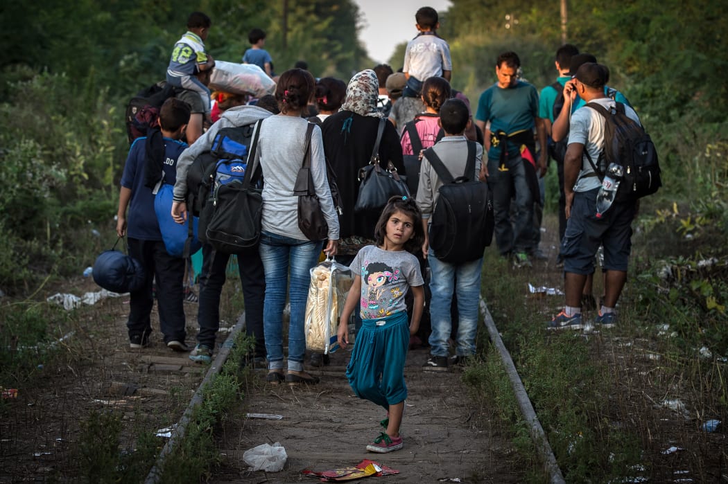 Migrants walk down a railroad towards Hungary near the northern Serbian town of Horgos.
