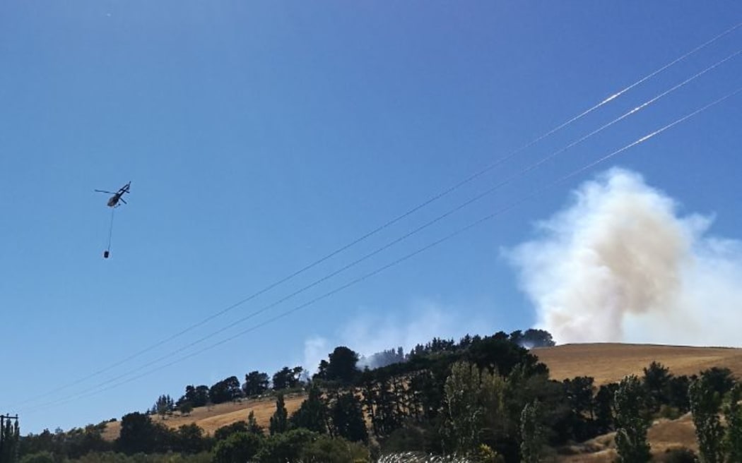 A helicopter is seen fighting a fire in Christchurch's Port Hills.