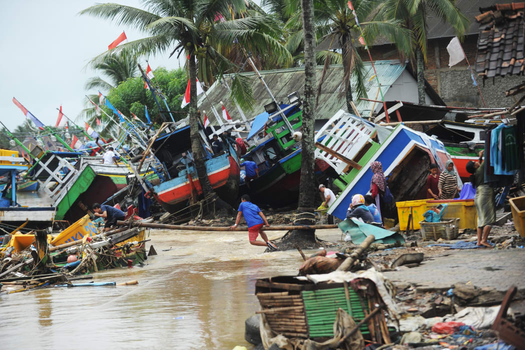 Fishermen tend to their traditional fishing boats which were damaged after being hit by a tsunami in the Teluk village, Labuan subdistrict in Banten province on 25 December, 2018.