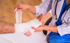 Injury leg. Young man with injured leg. Young woman doctor helps the patient