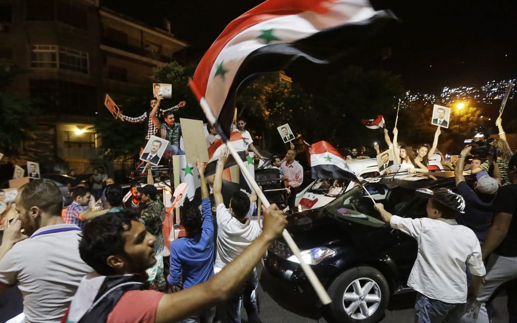 Syrians celebrate the vote's outcome in the capital Damascus.