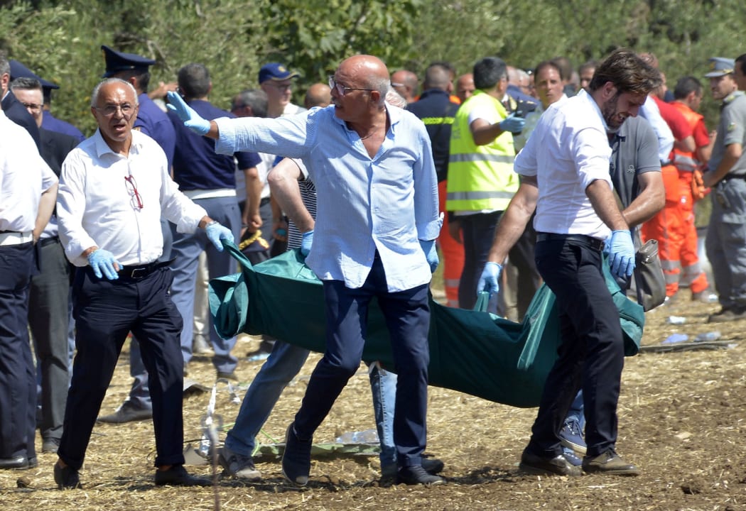 Rescuers carry a coffin after a head-on collision between two trains, near Corato, in the southern Italian region of Puglia on July 12, 2016.