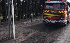 A fire tanker monitors the area of a scrub fire in Fernhill, near Hastings on Wednesday morning after it engulfed trees late last night.
