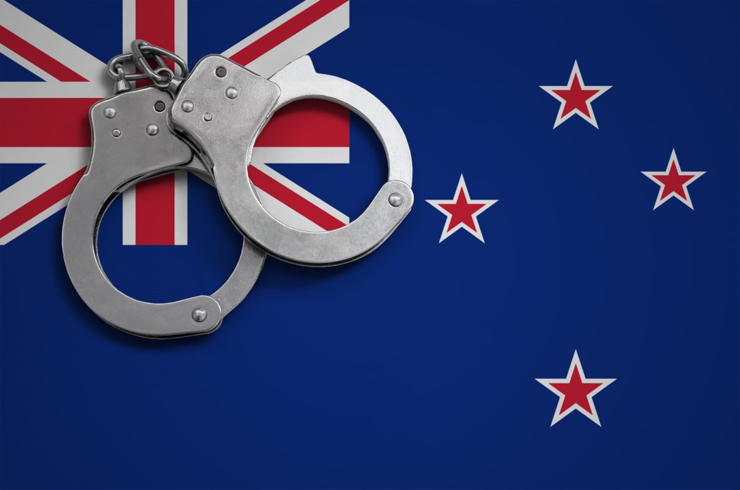 New Zealand flag  and police handcuffs. The concept of crime and offenses in the country.
