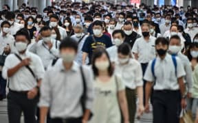 People commute early morning in Tokyo on August 17, 2020.