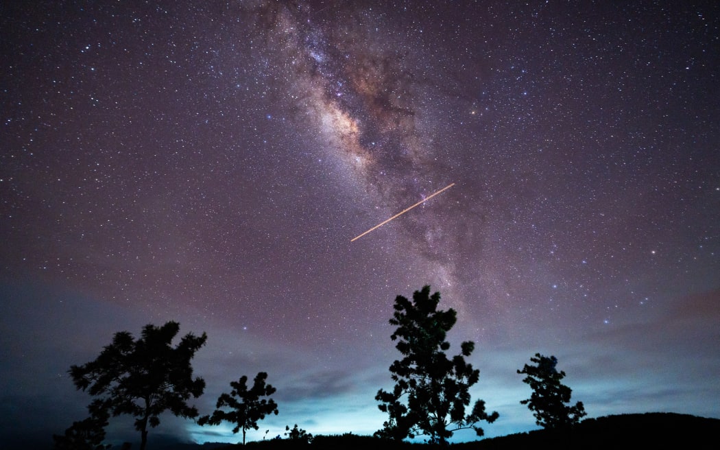 A flight-illuminated path and the Milky Way are appearing in the night sky during the Eta Aquarids meteor shower, which is peaking in Ratnapura, Sri Lanka, on May 5, 2024. The Eta Aquarids Meteor Shower is an annual event caused by Earth passing through debris left behind by Halley's Comet. Named after the constellation Aquarius, these meteors are streaking across the sky at high speeds, creating a dazzling display of shooting stars. Best observed in the predawn hours away from city lights, it is a mesmerizing celestial event cherished by skywatchers worldwide. (Photo by Thilina Kaluthotage/NurPhoto) (Photo by Thilina Kaluthotage / NurPhoto / NurPhoto via AFP)