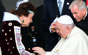 Pope Francis meets a member of an indigenous tribe during his welcoming ceremony at Edmonton International Airport in Alberta, western Canada, on July 24, 2022. - Pope Francis visits Canada for a chance to personally apologize to Indigenous survivors of abuse committed over a span of decades at residential schools run by the Catholic Church. (Photo by Vincenzo PINTO / AFP)