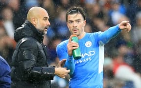 Manchester City manager Pep Guardiola  gives instructions to Jack Grealish