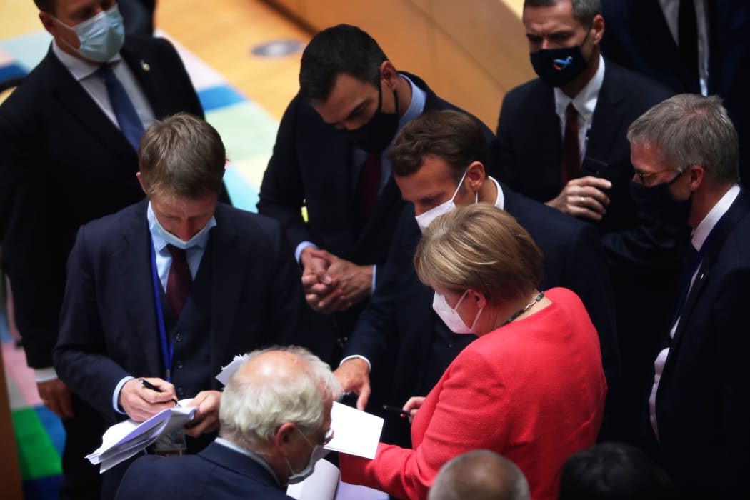 German Chancellor Angela Merkel speaks with Spain's Prime Minister Pedro Sanchez (centre) and French President Emmanuel Macron during a round table meeting at an EU summit over a post-virus economic rescue plan in Brussels, on July 20, 2020.