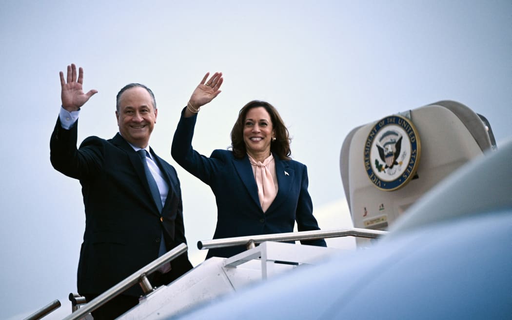 US Vice President and 2024 Democratic presidential candidate Kamala Harris and Second Gentleman Doug Emhoff wave as they depart from Philadelphia International Airport in Philadelphia, Pennsylvania, August 6, 2024. Harris spoke during a campaign event at Temple University and is returning to Washington, DC. (Photo by Brendan SMIALOWSKI / POOL / AFP)