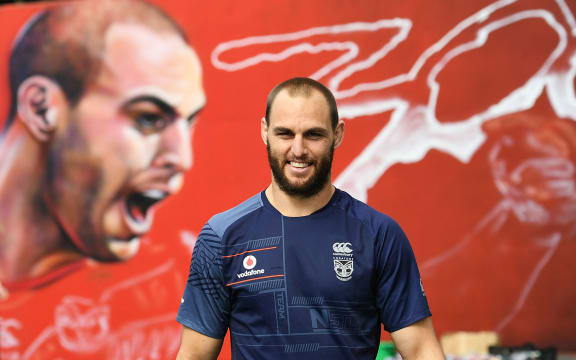 Simon Mannering in front of a mural for his 300th match created by artist Emily Gardner aka Adore.