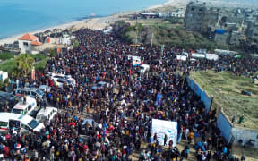 This aerial photo shows displaced Gazans gathering in an area in Nuseirat on January 26, 2025, to return to their homes in the northern part of the Gaza Strip.