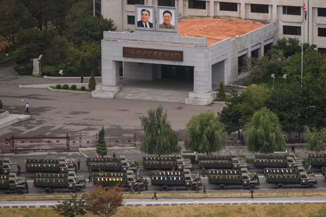 Empty military vehicles ahead of the parade before a building displaying portraits of late North Korean leaders Kim Il-Sung (top L) and Kim Jong-Il (top R) in Pyongyang.
