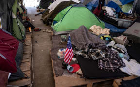 Central American migrant travelling in a caravan sits in her tent at El Barretal temporary shelter on the US-Mexico border in Tijuana, Baja California state, Mexico, on January 22, 2019.