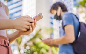 Contact tracing app COVID-19 pandemic coronavirus. People wearing masks using phones.