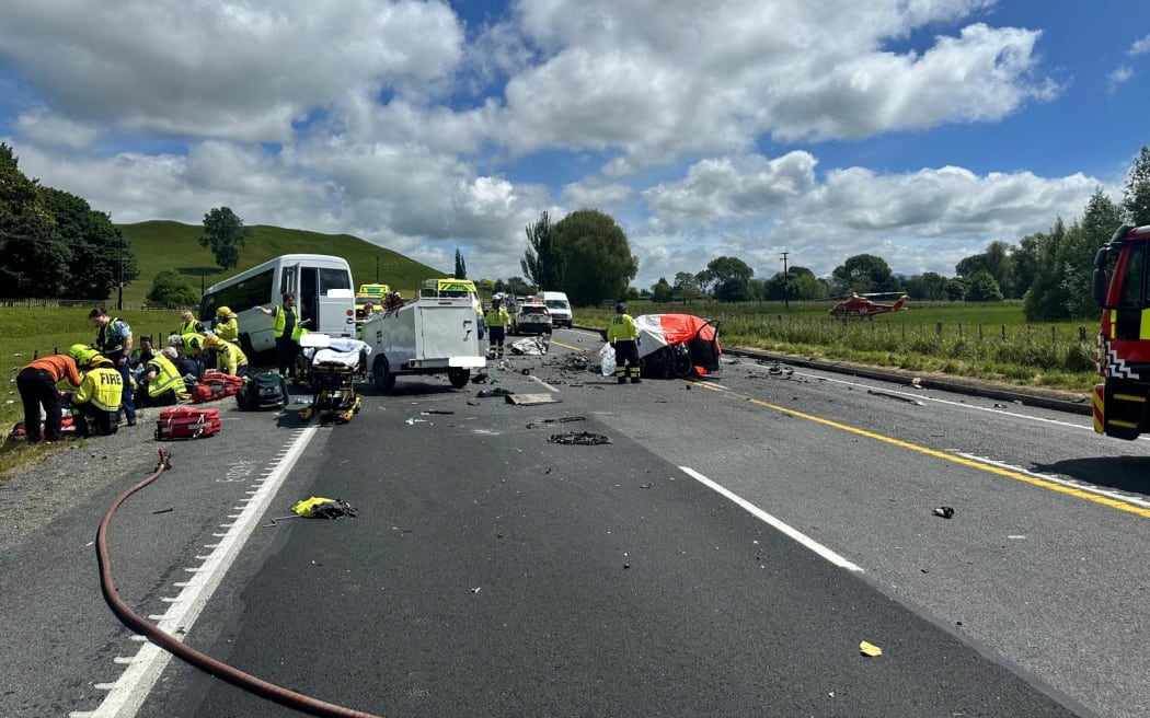 One person is dead and 14 others are injured after a small bus loaded with international tourists collided with two vehicles on a straight stretch of State Highway 1.