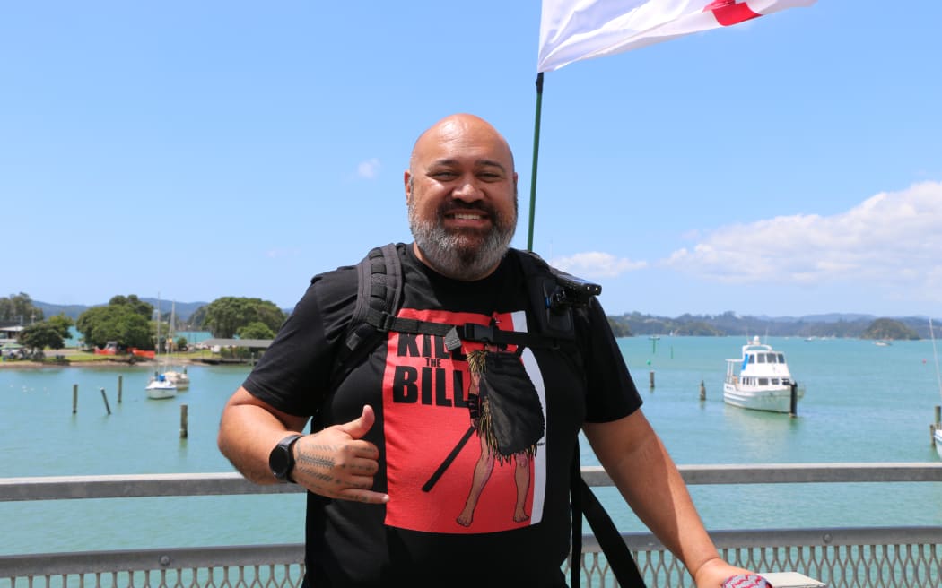Professional Artist Michel Mulipola, known as 'Bloody Samoan,' designed the 'Kill the Bill' artwork - as seen on his t-shirt - a nod to Te Pāti Māori MP Hana Rawhiti Maipi Clarke ripping up the Treaty Principles Bill.