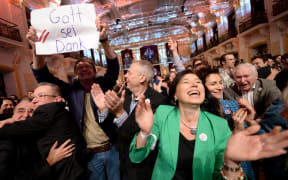 Supporters of the Alexander Van der Bellen,one holding a sign reading "Thank God" celebrate as early results come in.