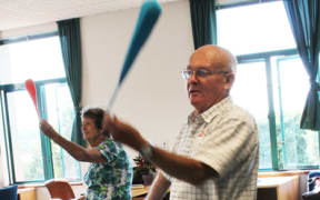 Two older people using poi