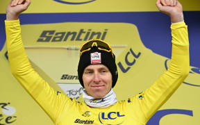Slovenian rider Tadej Pogacar celebrates on the podium, 2025 Tour de France.