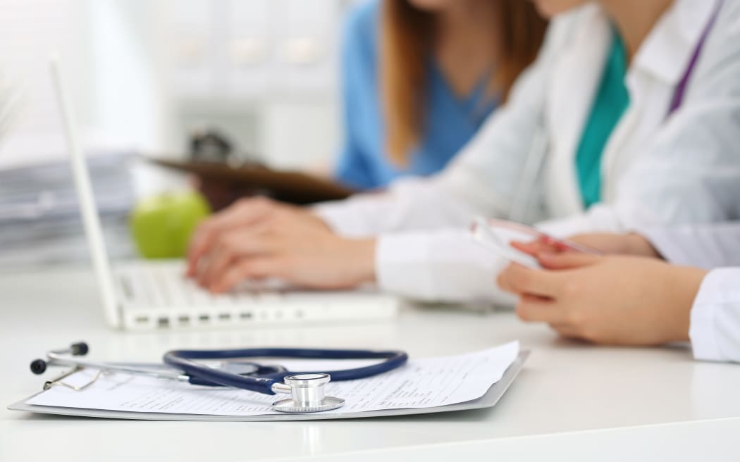 Healthcare staff, doctors, nurse, working on laptop.