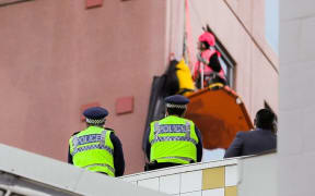 Police keep an eye as Greenpeace activists climb Wellington's Majestic Centre, the city's tallest building.