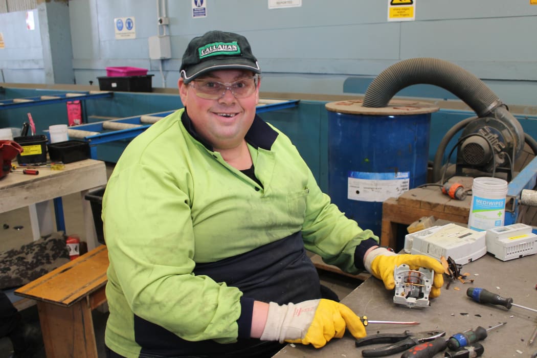 A photo of Greg Duncan breaking power meters down into recyclable e-scrap