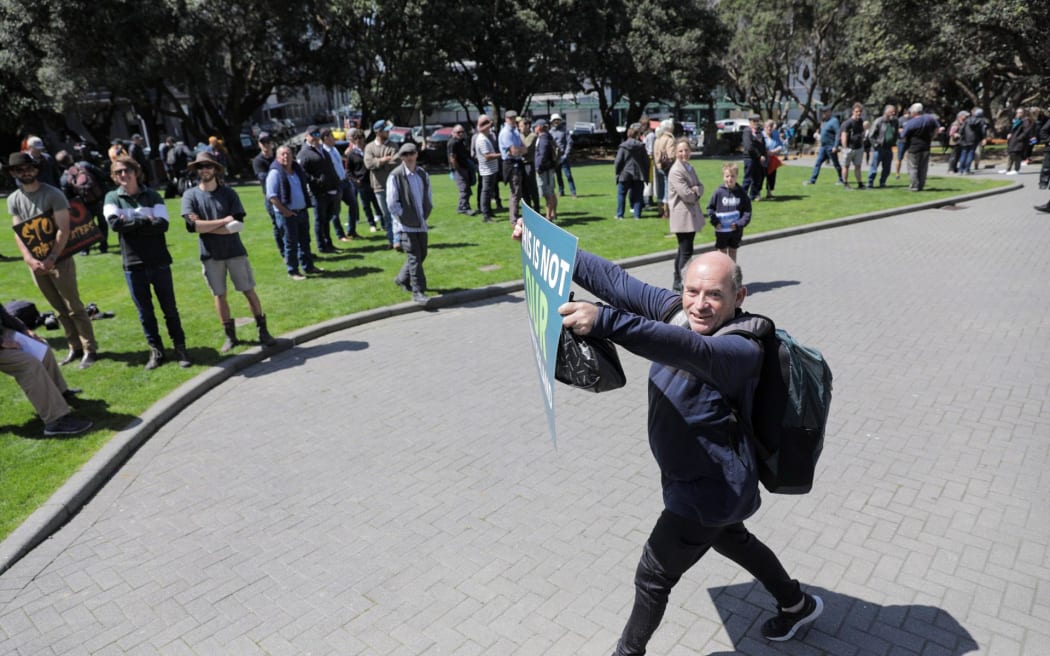 A groundswell protester among a scattered crowd on Parliament's lawn.