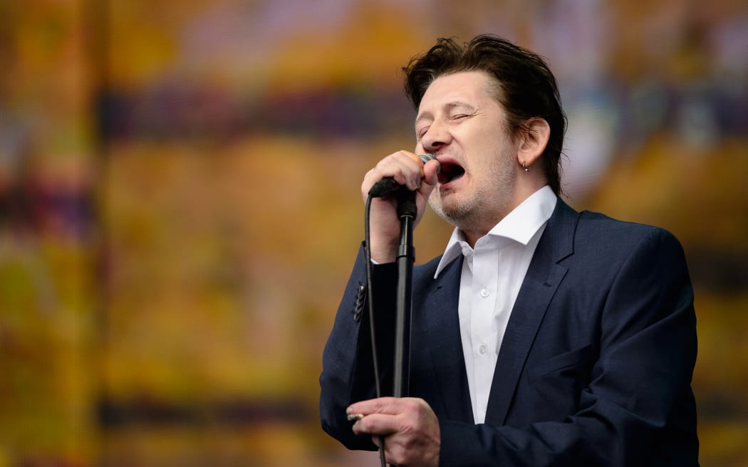 (FILES) Shane MacGowan of British group The Pogues performs on stage at the British Summer Time festival in Hyde Park in central London, on July 5, 2014. Shane MacGowan, songwriter and lead singer of folk-punk group The Pogues, has died aged 65 after a long illness, his wife announced on November 30, 2023. (Photo by LEON NEAL / AFP)