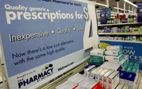In this file photo taken on September 22, 2006, a large poster announces new prices inside the WalMart pharmacy in Clearwater, Florida.