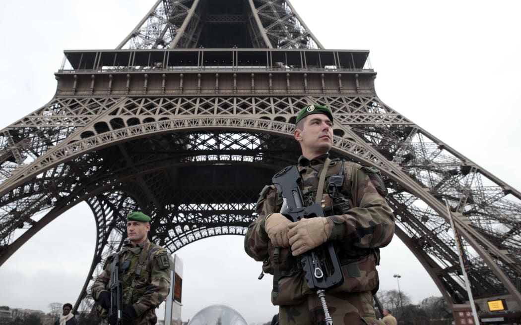 A French soldier in front of the Eiffel Tower as the capital is placed under the highest alert status.