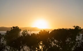 The sun rises at the Upper Marae on Waitangi Day. 6 February 2017.