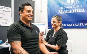 Te Puna Ora o Mataatua contracts manager Arapeta Taitoko is all smiles as he receives his vaccine from Kelly Gavin.